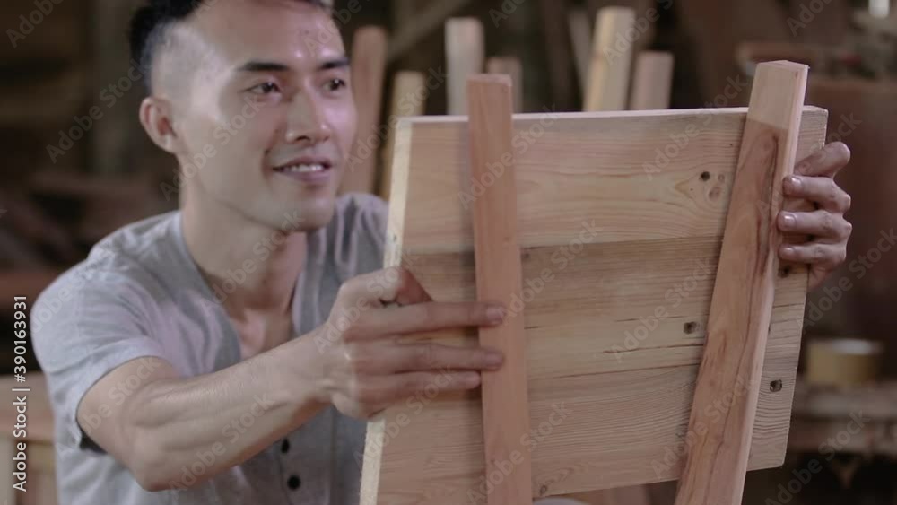 selective focus of carpenters smile when holding wooden planks to be installed as chair backs in the workshop selective focus of carpenters smile when holding wooden planks to be installed as chair backs in the workshop