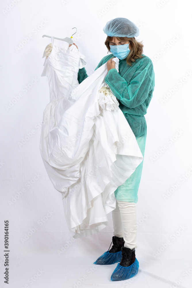 woman in nurse outfit showing her wedding dress on white background woman in nurse outfit showing her wedding dress on white background