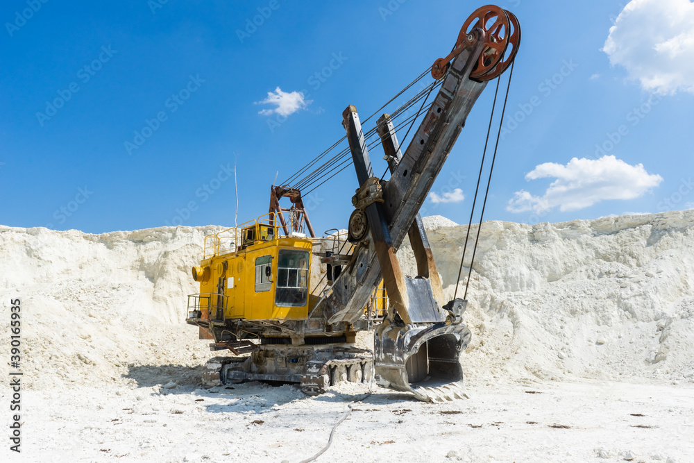 Large old yellow excavator at a construction site in a quarry. Industrial image. Large old yellow excavator at a construction site in a quarry. Industrial image.