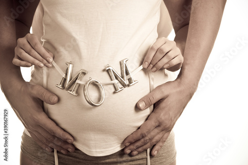 Pregnant woman and mans hands holding belly photo