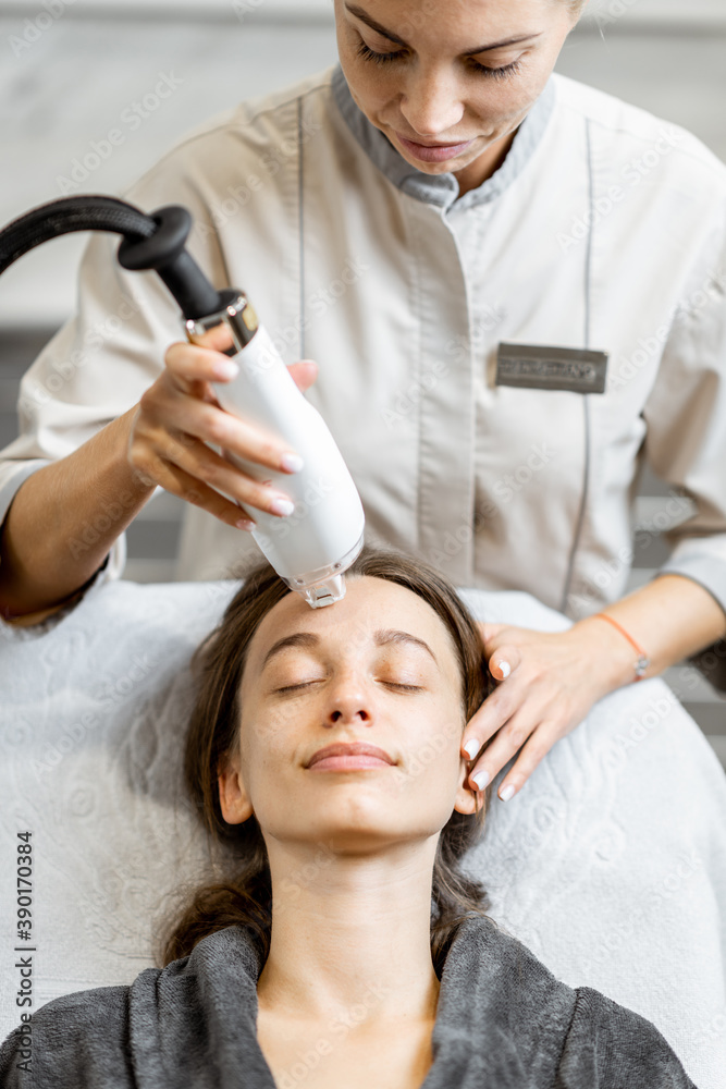 Female doctor making a laser rejuvenation treatment for a young woman client at medical office. LaseMD procedure Female doctor making a laser rejuvenation treatment for a young woman client at medical office. LaseMD procedure