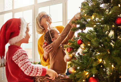 Fotografi happy family grandmother and grandchildren decorate the Christmas tree for the holiday