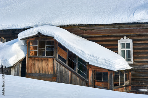 The roof of the house is covered with snow