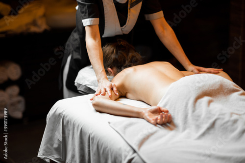 Young woman receiving a back massage while relaxing at Spa salon
