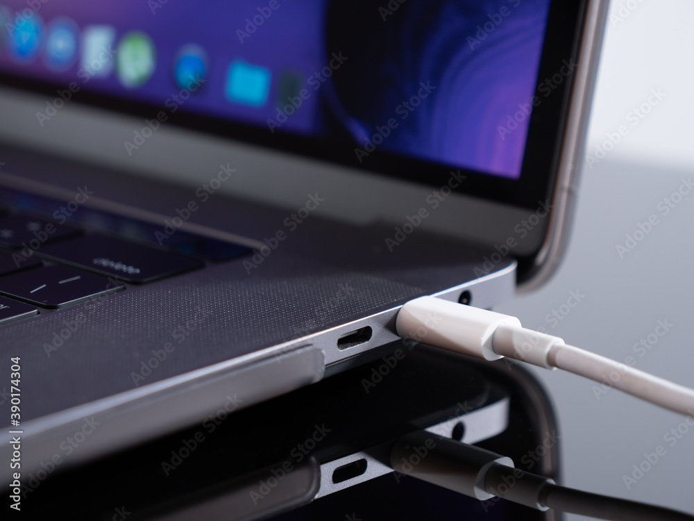 USB Type C cable being connected to the laptop computer. Fast charging