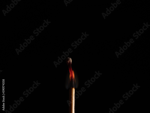 Burned match stick isolated on black background.