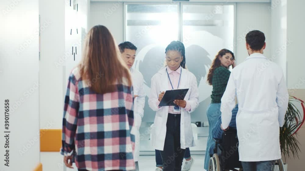 Modern hospital concept. Crowd of medical workers and sick patiens walking through corridor communicating. Healthcare office. Private clinic. Multi-ethnic people. Modern hospital concept. Crowd of medical workers and sick patiens walking through corridor communicating. Healthcare office. Private clinic. Multi-ethnic people.