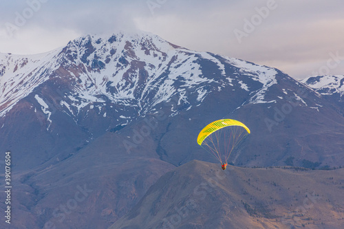 Paragliding against snow-capped Andes mountains during winter season in Esquel, Patagonia, Argentina