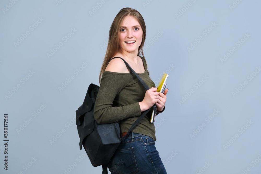 Portrait of smiling university student with backpack on gray background Portrait of smiling university student with backpack on gray background