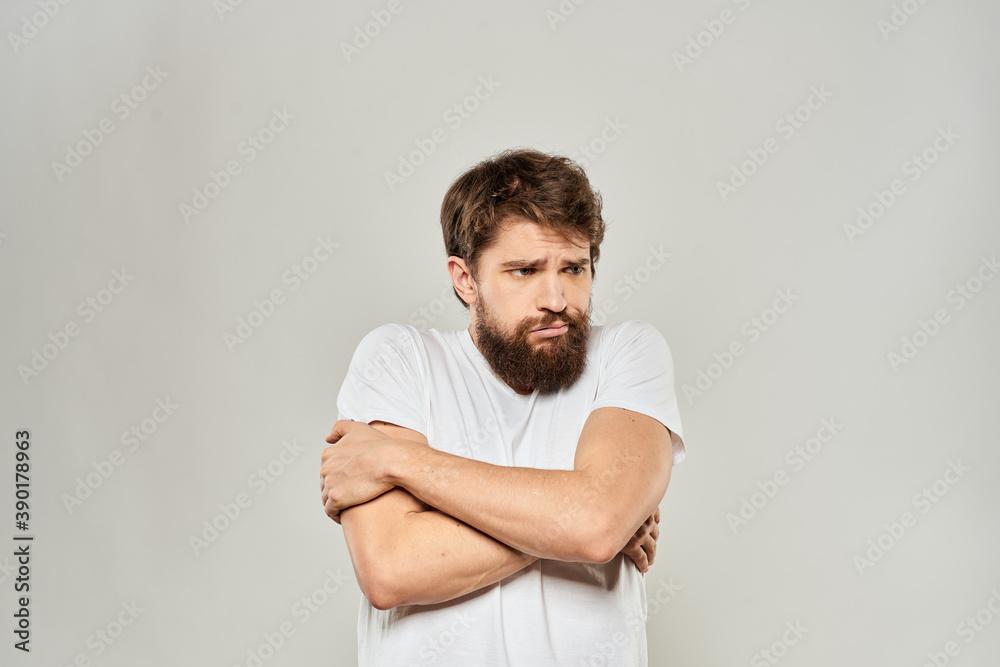 man in white t-shirt gesturing with his hands studio dissatisfaction lifestyle light background man in white t-shirt gesturing with his hands studio dissatisfaction lifestyle light background