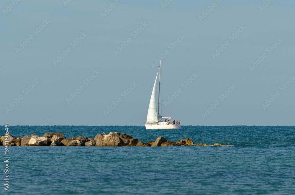 Sailboat in the middle of the sea near the coast