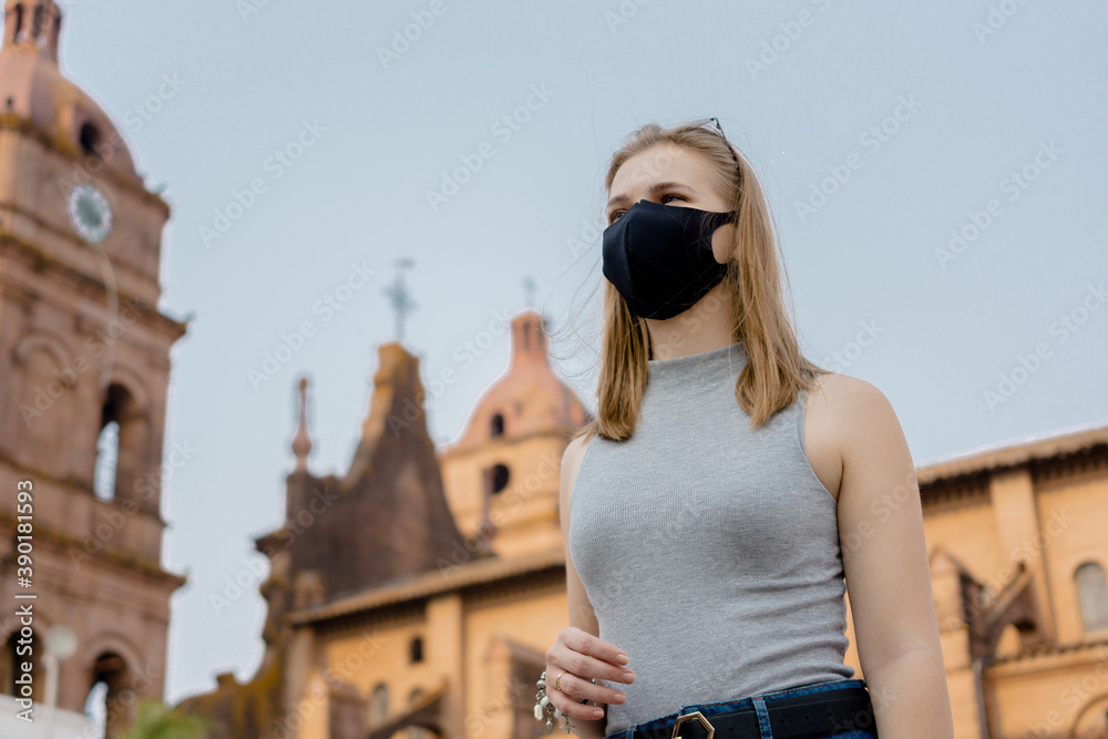 Low angle shot of a female wearing a facemask while walking outside