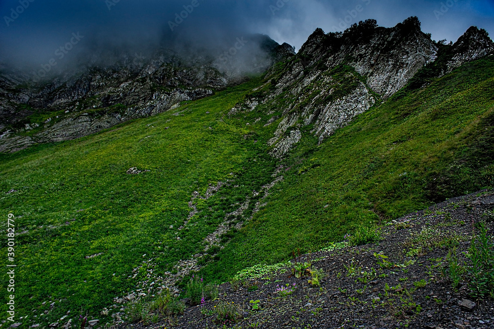 Obraz premium Mountain landscape Green mountains of Aibga ridge and rain cloudy sky Trekking in the mountains, active lifestyle, copy space, natural background