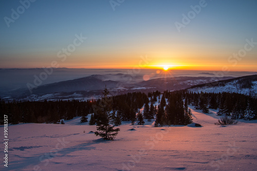 Breathtaking view of a landscape covered with snow during the sunset