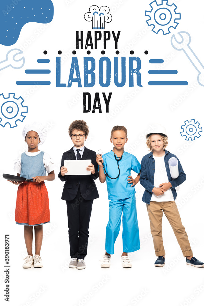 Fototapeta premium multicultural children in costumes of different professions near happy labour day lettering on white