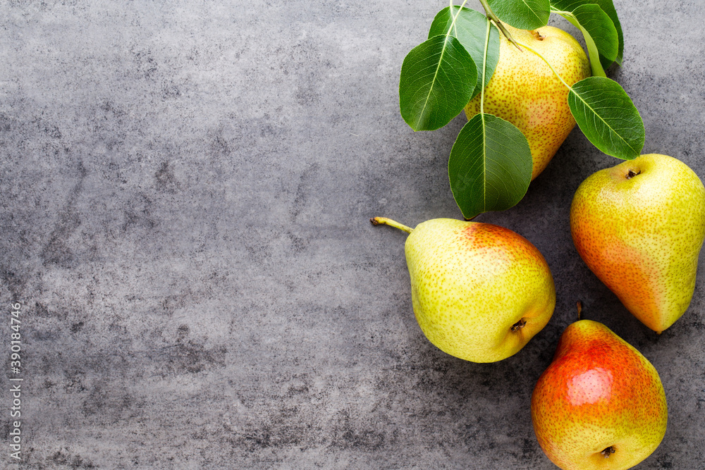 Fresh bio pear with leaves on the plate. Gray stone table. Fresh bio pear with leaves on the plate. Gray stone table.