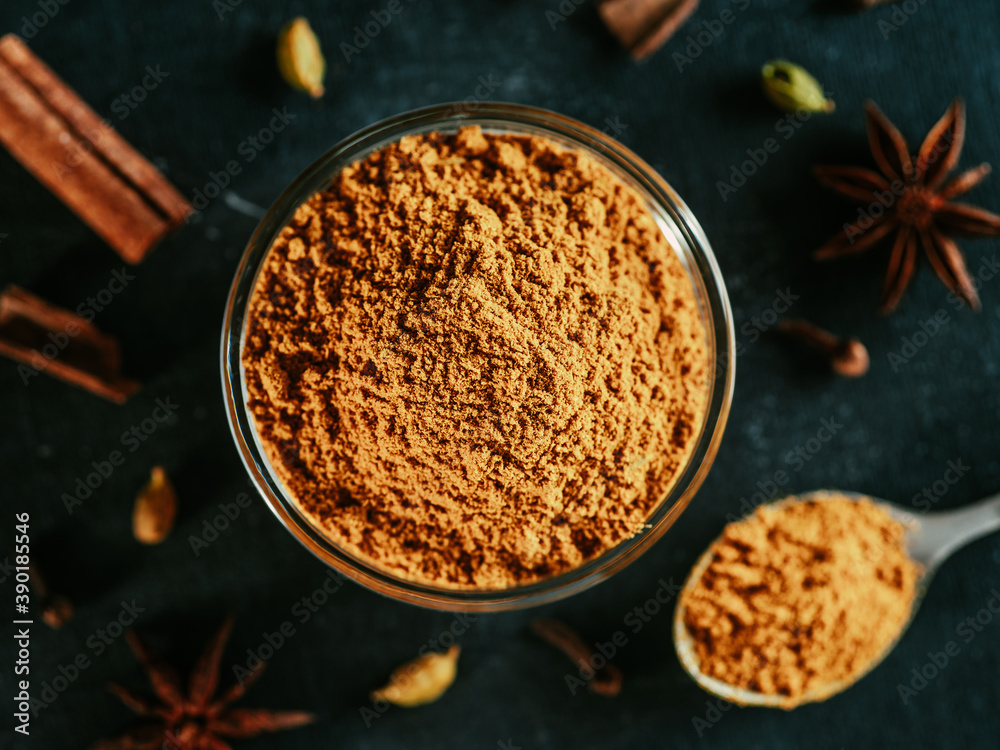 Indian or pakistani masala powder in spoon and small glass bowl. Close up  view of homemade dry curry garam masala mix spices blend on dark background.  Stock Photo | Adobe Stock