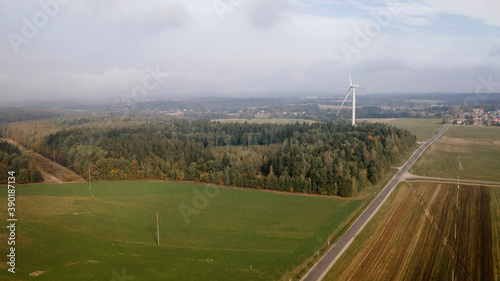 From above of picturesque view of large agricultural field with contemporary windmills located on clearing covered with fog in morning. Space for text. Design concept.