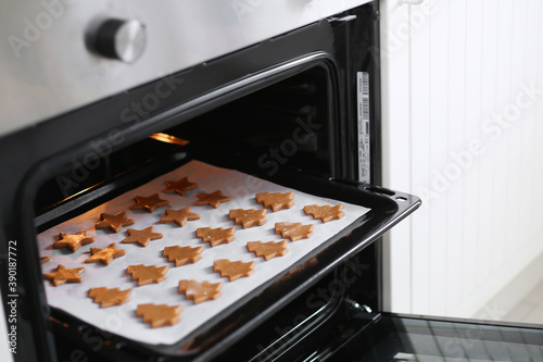 Making christmas gingerbread cookies. Cutting Christmas ginger cookies in the oven