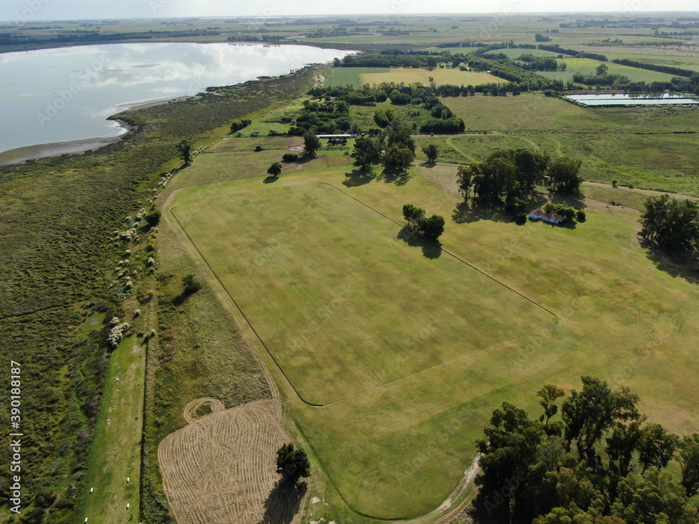 Vista aérea de una cancha de polo, con una laguna al fondo. Stock Photo