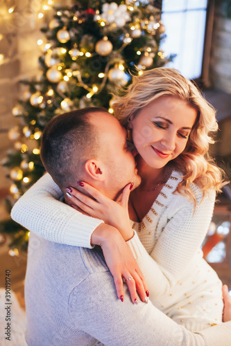  lovers cuddling on the bed near the christmas tree