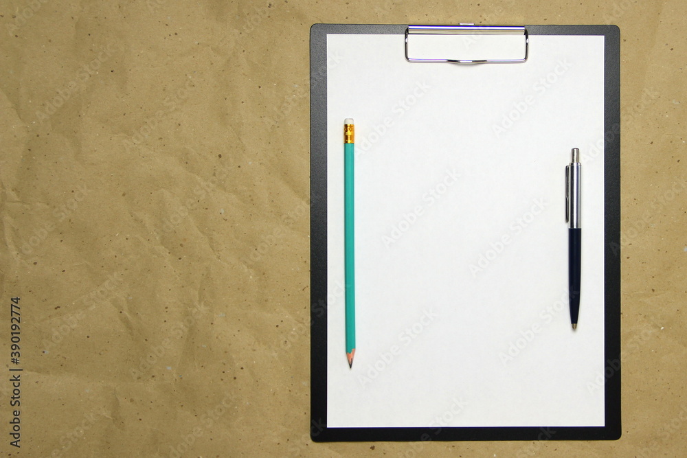 A tablet with a white sheet of A4 format on a beige craft paper. A tablet with a white sheet of A4 format on a beige craft paper.