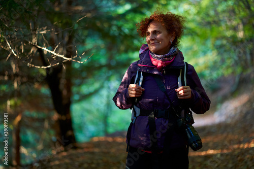 Female nature photographer hiking into the forest