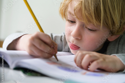 Boy (4-5) doing homework photo