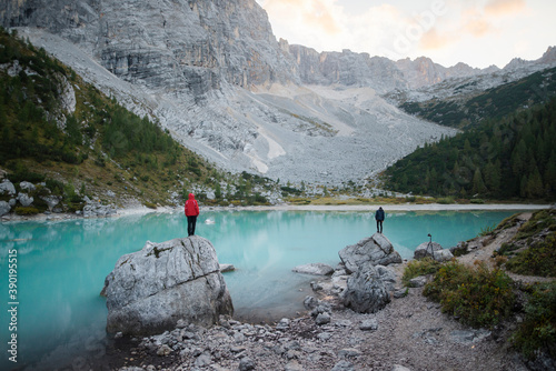 Italy, South Tyrol, Cortina d Ampezzo, lake Sorapis, Men standing on top of rock formations looking at view photo