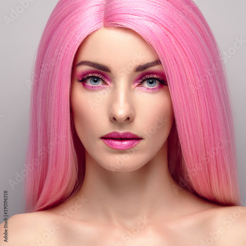 Beauty Fashion woman with Colorful Pink Dyed Hair. Girl with blue eyes, perfect Makeup and Hairstyle. Beautiful smiling model portrait, fashionable pink make up, hair. Skincare concept