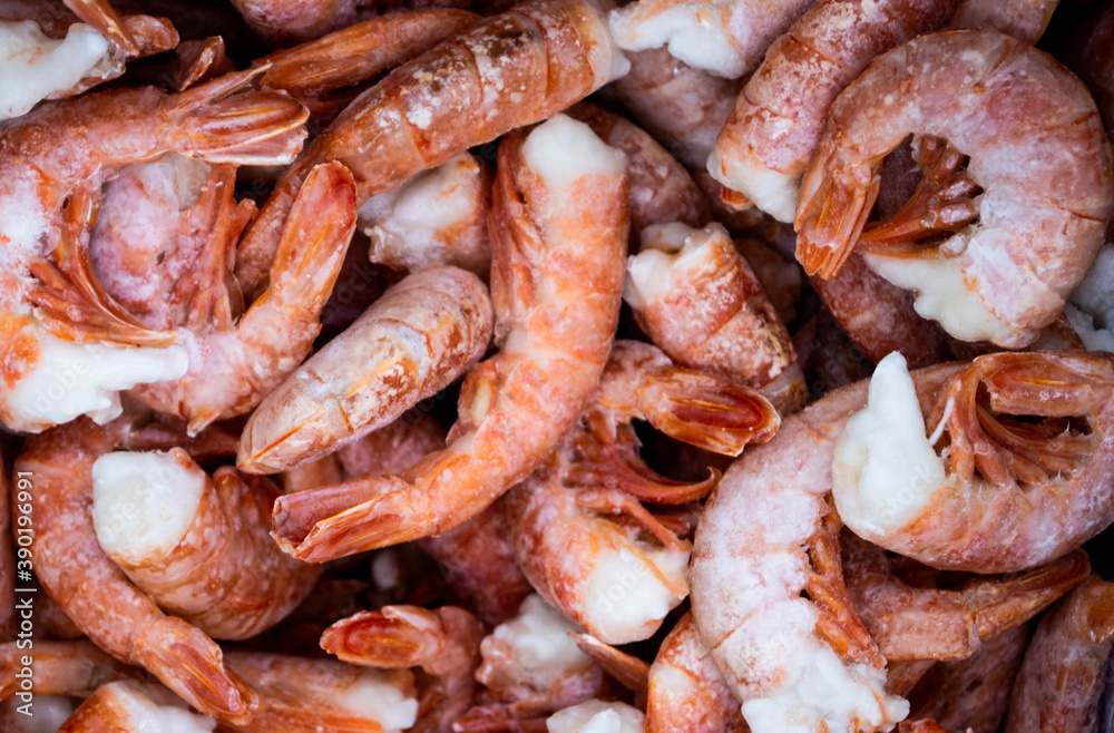Close-up of a pile of large frozen red shrimps. Natural bright seafood background Close-up of a pile of large frozen red shrimps. Natural bright seafood background