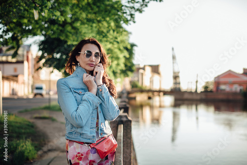 Beautiful aged woman posing on the river embankment.