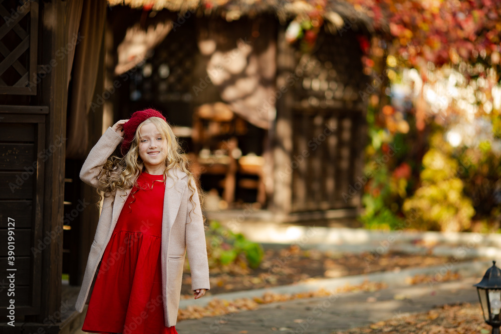 Cute girl in red beret on a walk in the fall