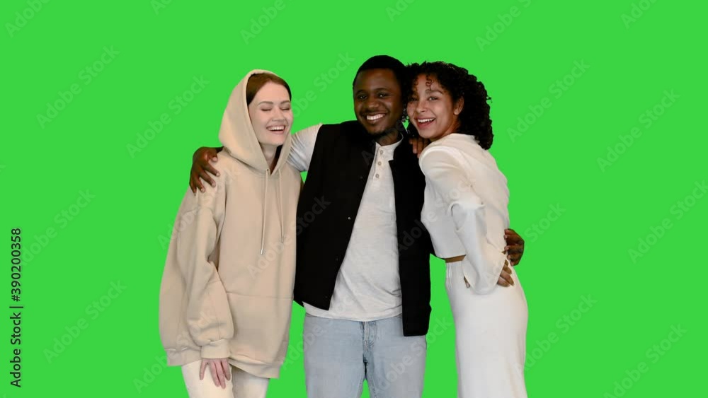 Young Multiethnic Friends Smiling to Camera on a Green Screen, Chroma Key. Young Multiethnic Friends Smiling to Camera on a Green Screen, Chroma Key.
