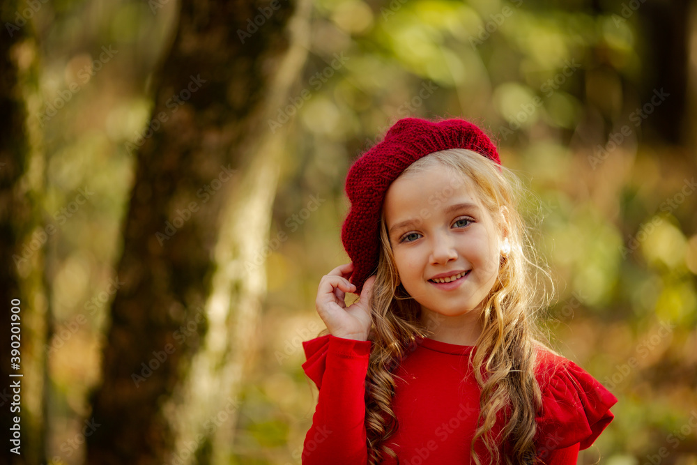 Cute girl in red beret on a walk in the fall