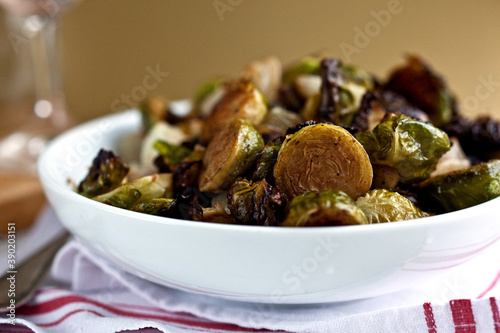 Close up of roasted brussels sprouts with pistachios and cipollini onions served in bowl photo