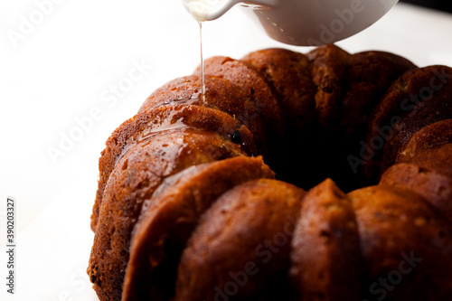 Close up of bourbon sugar syrup pouring on apple bourbon bundt cake photo