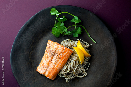 Overhead view of roasted arctic char with pine nut soba and meyer lemon served on plate photo