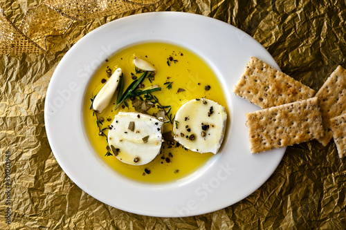Overhead view of marinated goat cheese served with crackers