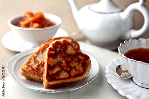 Heart shape whole wheat crumpets served with tea on table photo