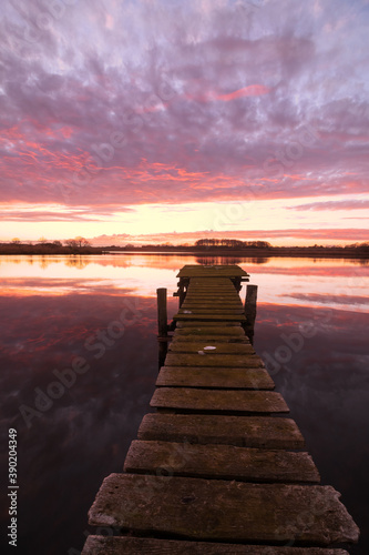 wooden jetty by the lake with red sky