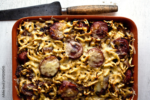 Overhead view of spaetzle with smoked kielbasa and caramelized onions served in tray photo
