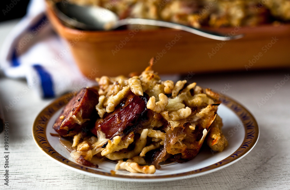 Close up of spaetzle with smoked kielbasa and caramelized onions served on plate Close up of spaetzle with smoked kielbasa and caramelized onions served on plate