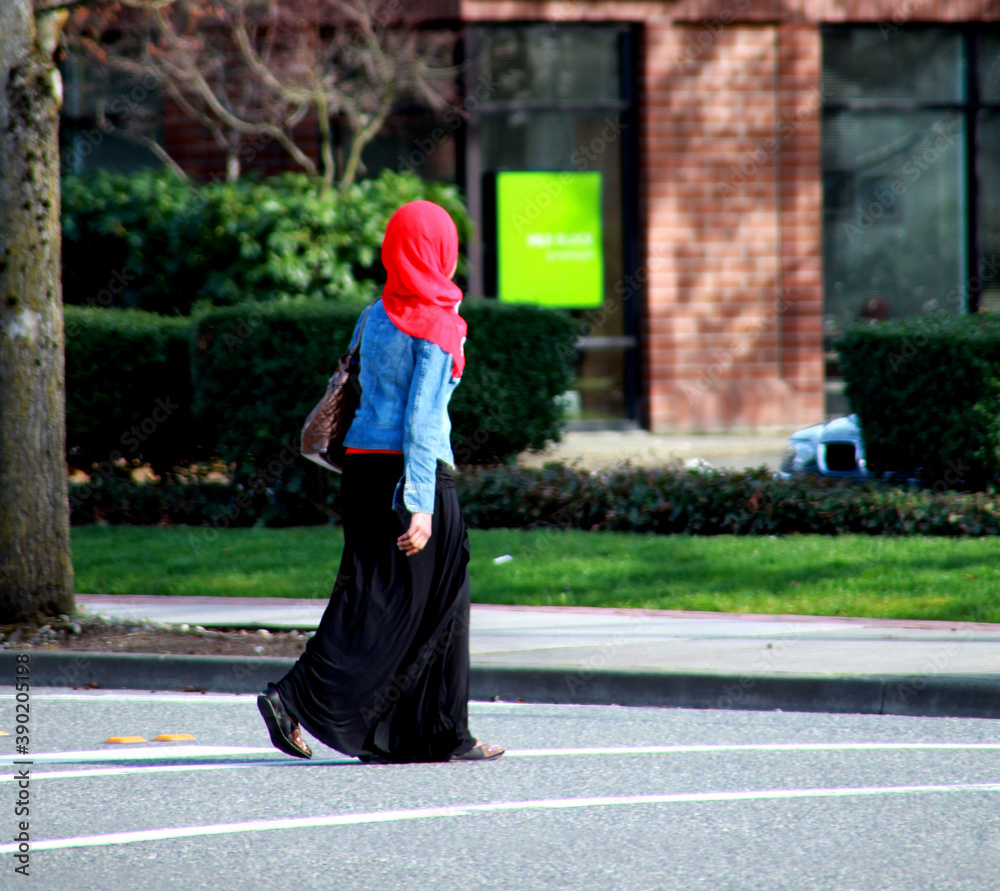 Muslim woman crossing the street outside.