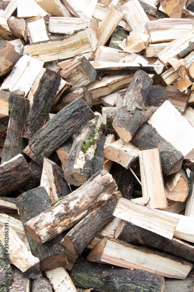 Heap of chopped firewood background. Pile of split firewood. Stack of fuel wood. Vertical view Heap of chopped firewood background. Pile of split firewood. Stack of fuel wood. Vertical view