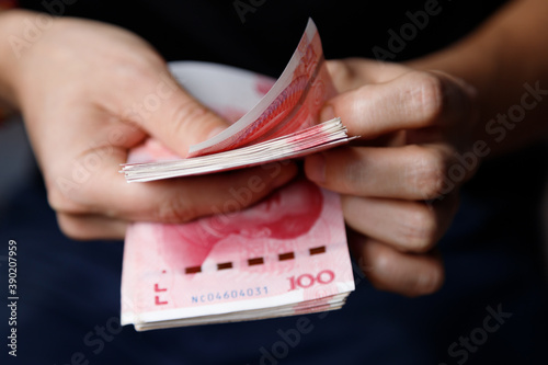 Man counts yuan. Currency of the China - One red hundred renminbi or yuan notes photo