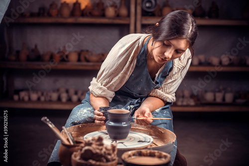 Beautiful young lady making ceramic pot on the pottery wheel . Concept for woman in freelance, business, hobby. photo