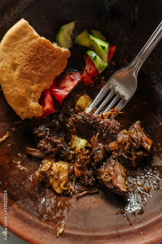 Plate of cooked meat with vegetables and fork photo