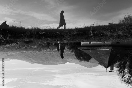 Lonely woman reflected in a pond