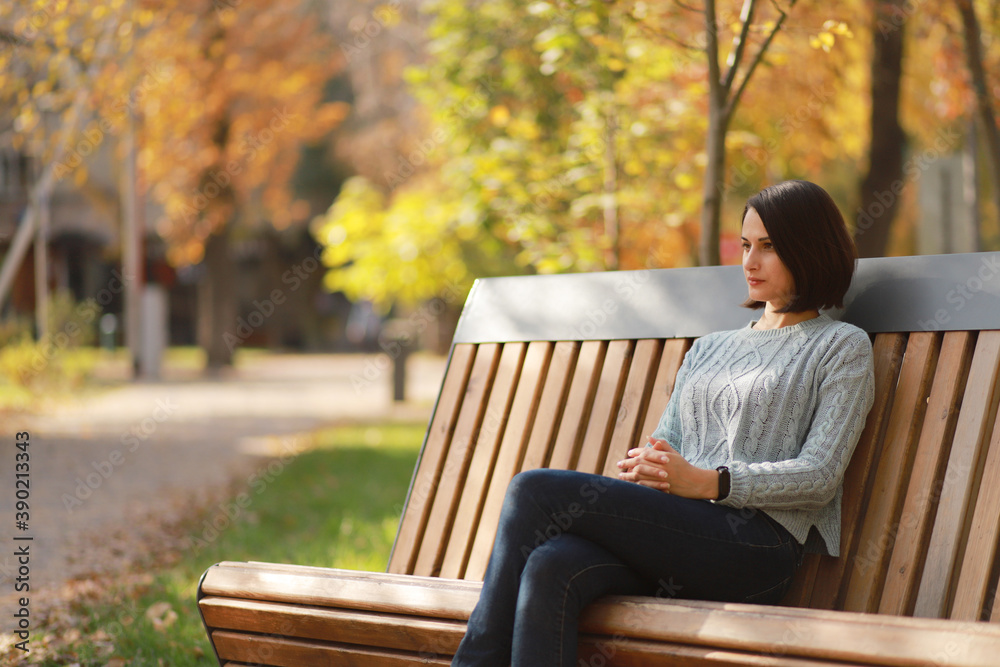 Young beautiful woman sitting on bench in autumn park. Young beautiful woman sitting on bench in autumn park.